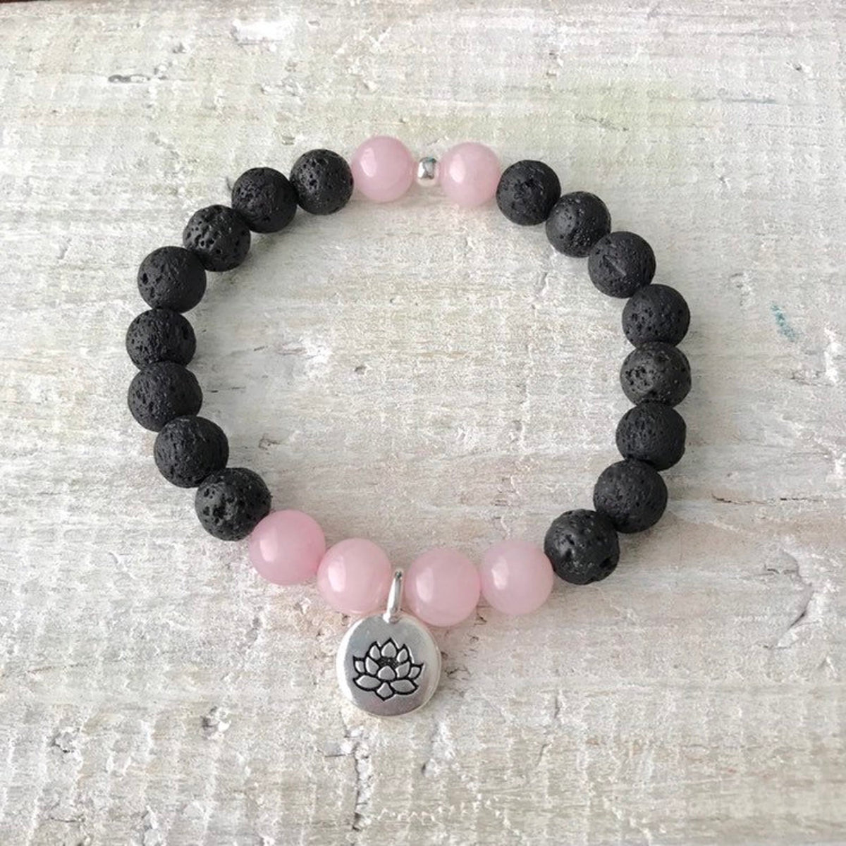 Rose quartz & lava stone Lotus Love Aromatherapy Bracelet by ZEN by Karen Moore on white wood