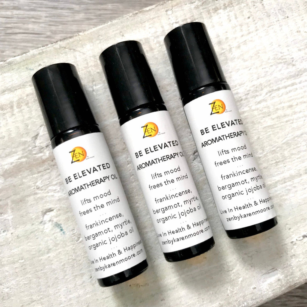 Frankincense, myrtle and bergamot BE Elevated Aromatherapy Essential Oil Roller Blend trio by ZEN by Karen Moore on white wood