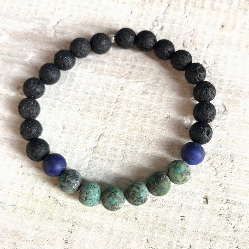 African turquoise, lapis lazuli & lava stone Stand Your Ground Aromatherapy Bracelet by ZEN by Karen Moore on white wood