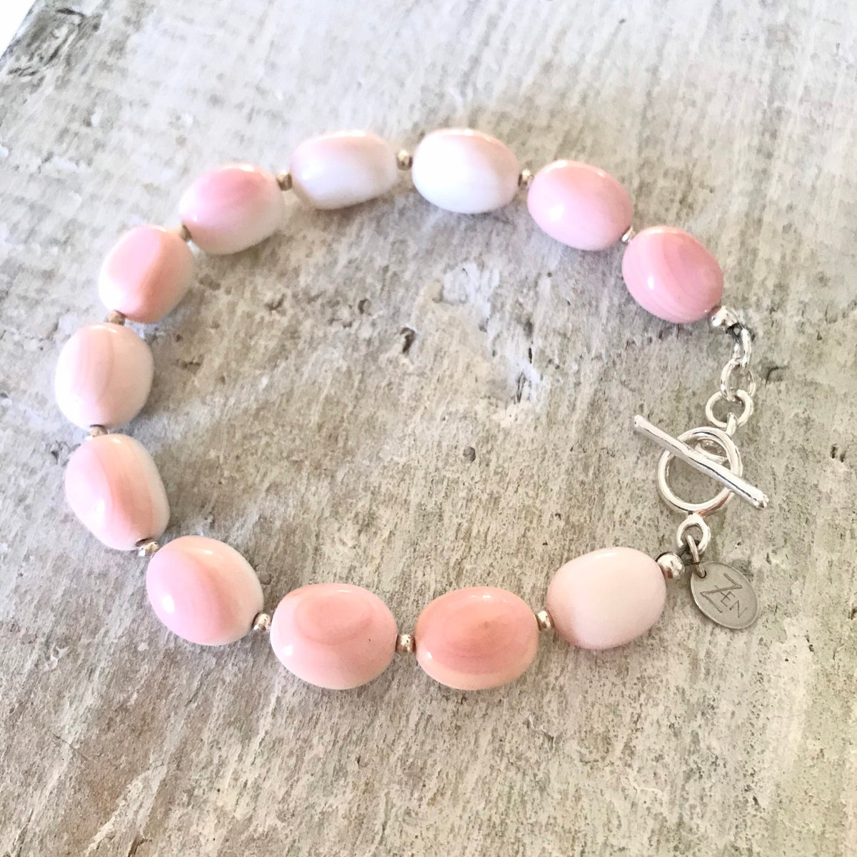 Conch shell Treasure Of Conch Shell bracelet with silver clasp by ZEN by Karen Moore on white wood