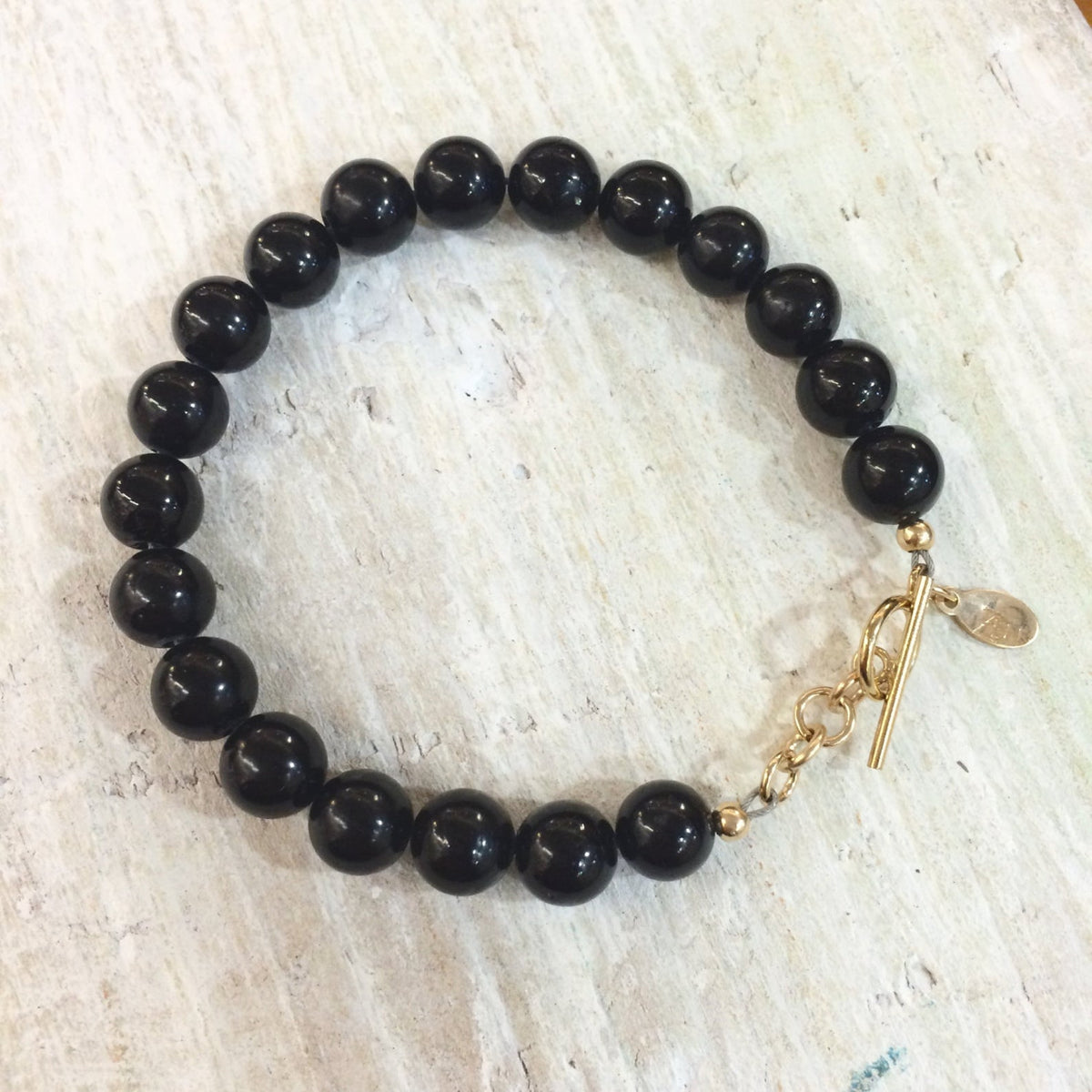 I Am Grounded rainbow obsidian bracelet by ZEN by Karen Moore on white wood
