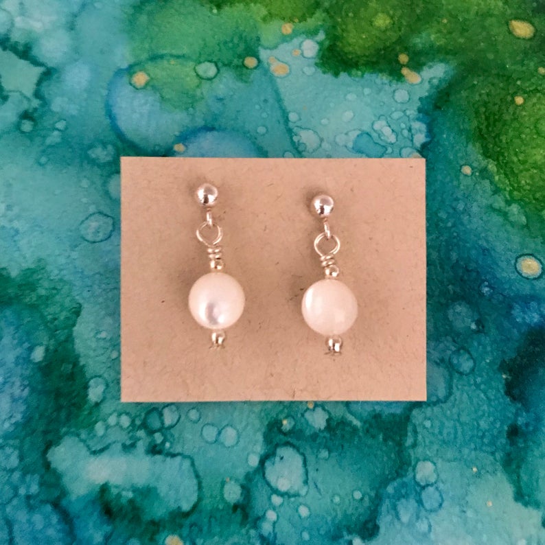 Pearl ZEN Mini Earrings by ZEN by Karen Moore featuring round pearl earrings on blue/green splatter background