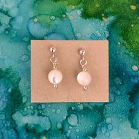 Pearl ZEN Mini Earrings by ZEN by Karen Moore featuring round pearl earrings on blue/green splatter background