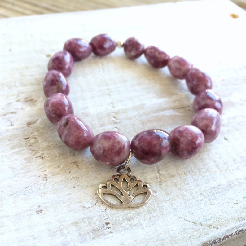 Let Go & Transform Lepidolite Bracelet by ZEN by Karen Moore front view of lotus charm on white wood