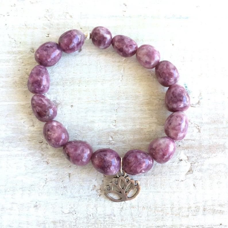 Let Go & Transform Lepidolite Bracelet by ZEN by Karen Moore overhead view of lotus charm on white wood