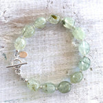 Reach Your Highest Potential prehnite bracelet by ZEN by Karen Moore overhead view on white wood