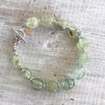 Reach Your Highest Potential prehnite bracelet by ZEN by Karen Moore overhead view with shadow on white wood