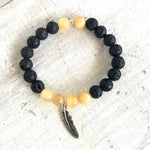 Calcite & lava stone Power Of The Positive Aromatherapy Bracelet by ZEN by Karen Moore close up view on white wood
