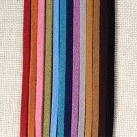 Rainbow of Eco ZEN Wrap jewelry suede bands by ZEN by Karen Moore on cream cloth