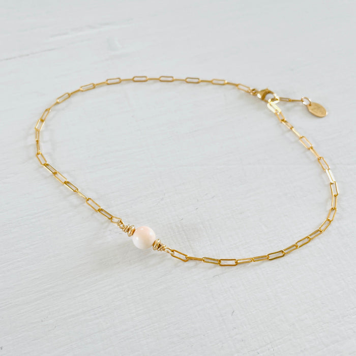 ZEN by Karen Moore Anchored in Clarity Conch Shell Anklet 14kt gold filled paperclip chain on white wood background