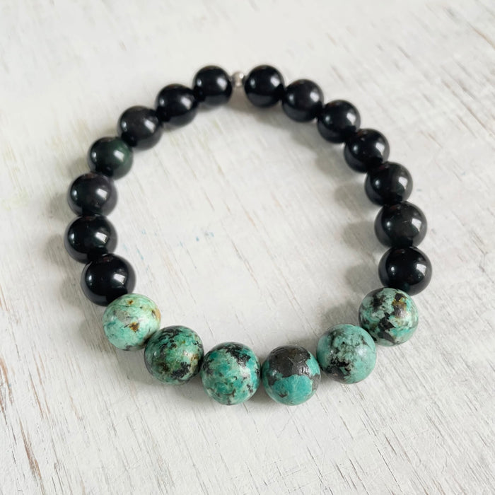 Grounded Health Turquoise & Obsidian Menz ZEN Bracelet by ZEN by Karen Moore on white wood background